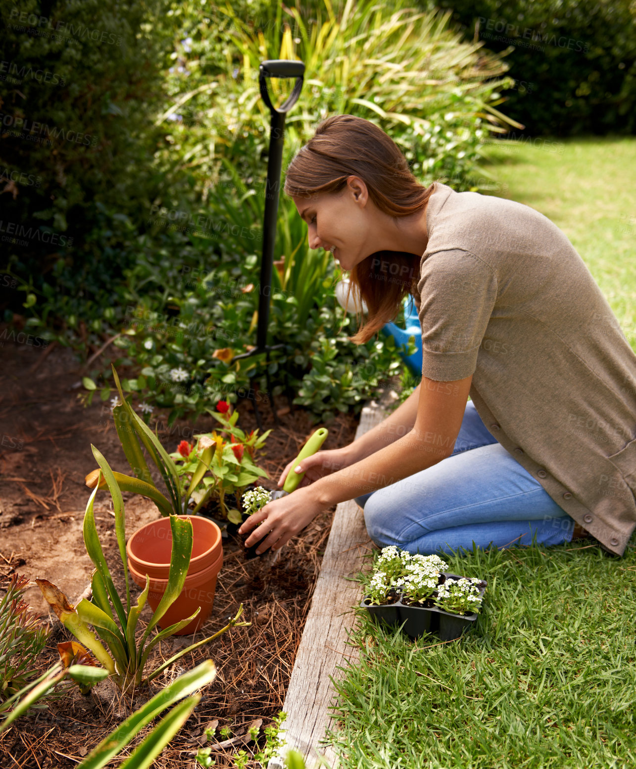 Buy stock photo Woman, flowers and gardening for agriculture in backyard with garden shovel, happiness and sustainability. Gardener, person and green fingers with plants and soil for growth or eco friendly hobby 