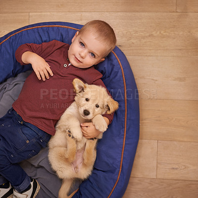 Buy stock photo An adorable little boy with his puppy at home