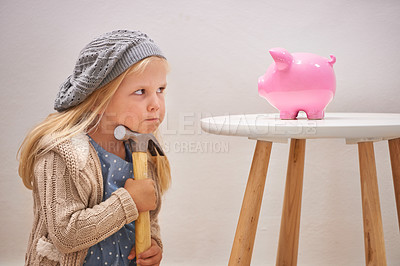 Buy stock photo A cute girl with a hammer eyeing her piggy bank