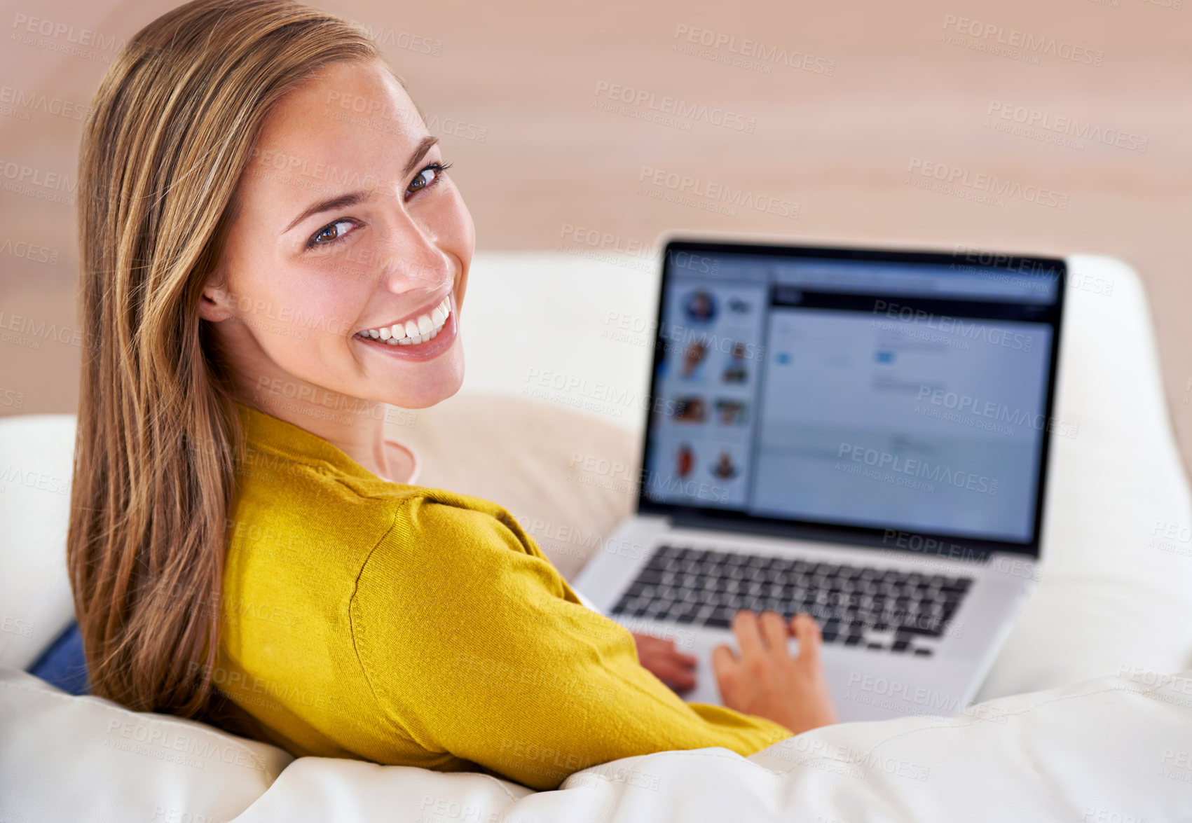 Buy stock photo Portrait of an attractive young woman using her laptop while sitting on the sofa at home