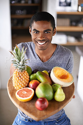 Buy stock photo Shot of a handsome young man proudly showing off his fresh produce