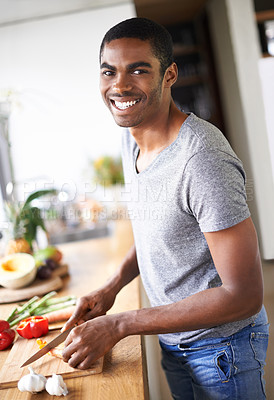 Buy stock photo African, man and cooking or chopping with smile, relaxed and happy morning at counter with confident male person. Kitchen, food and culinary in apartment, nutrition and organic vegetable or breakfast