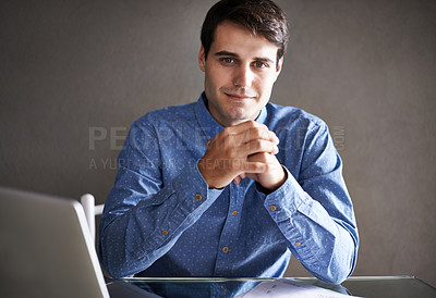 Buy stock photo Portrait of a successful young businessman sitting at his desk