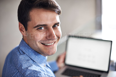 Buy stock photo Portrait of a young businessman looking over his shoulder while sitting with his laptop