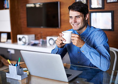 Buy stock photo A young businessman drinking coffee while sitting at his desk with a laptop
