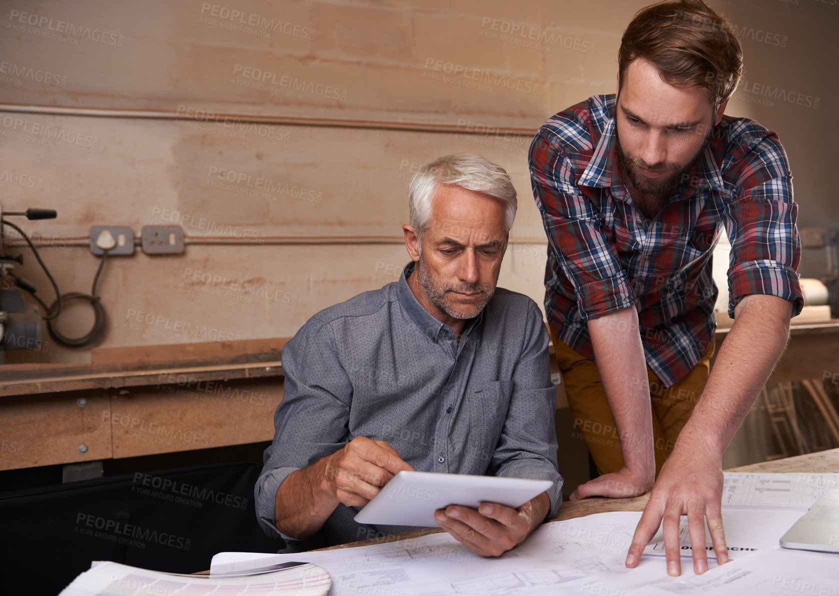 Buy stock photo Architect men, teamwork and planning with tablet, discussion and digital analysis of blueprint in workshop. Senior man, young partner and touchscreen for building, property or real estate development