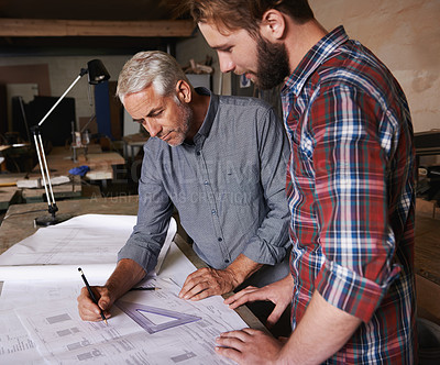 Buy stock photo Carpenter men, teamwork and drawing on paper with discussion, construction and design in workshop. Senior man, young male partner and paperwork for building, collaboration or woodworking company