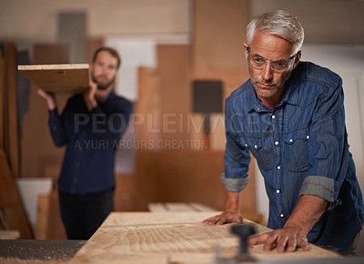 Buy stock photo Carpenter team, men in collaboration and work in workshop on design project with vocation and creative DIY skill. Teamwork, carpentry and male employee saw wood with father and son working together