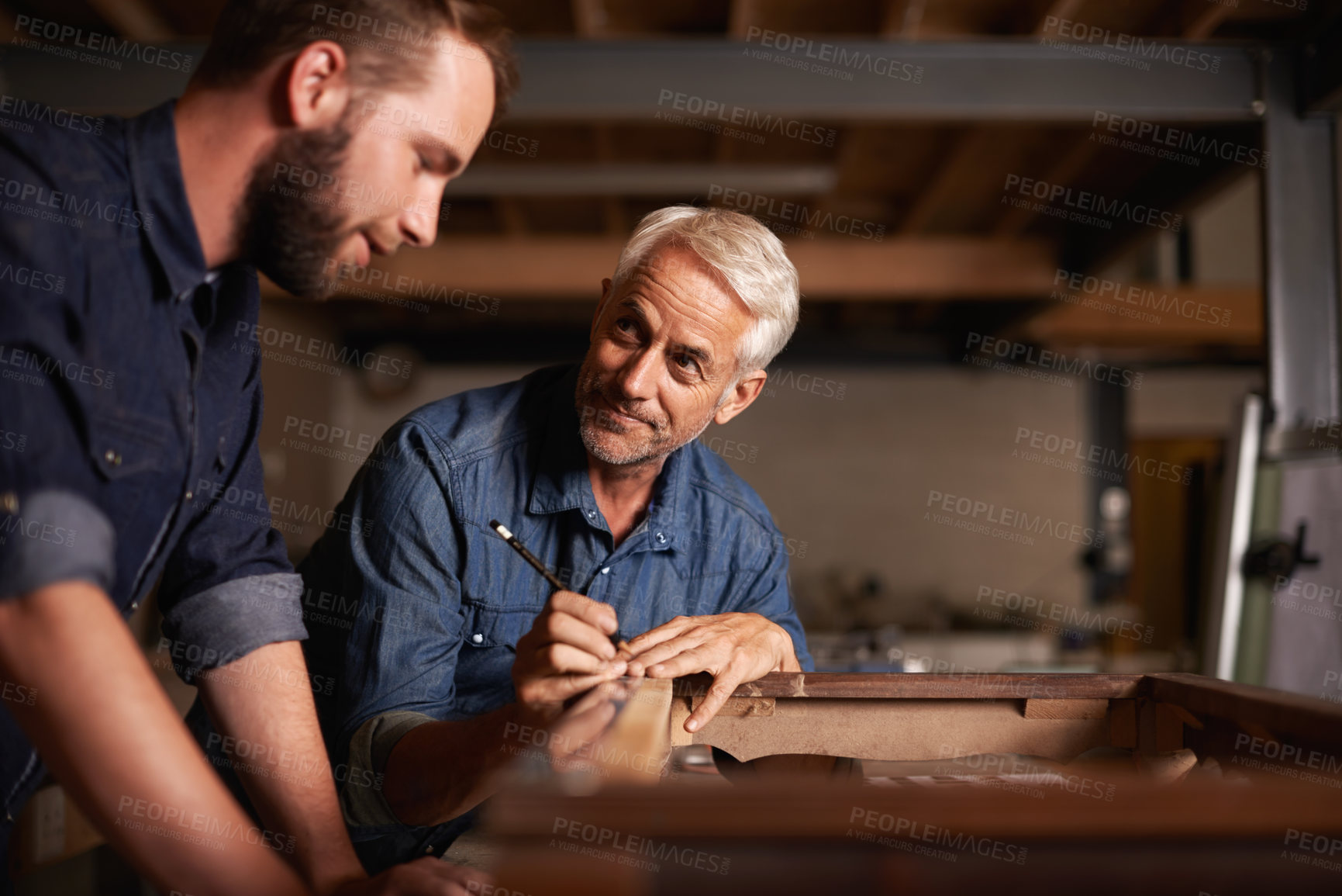 Buy stock photo Carpentry workshop, learning and man with apprentice teaching expert tips and help for furniture manufacturing. Mentorship, professional carpenter and student in training working on wood work project