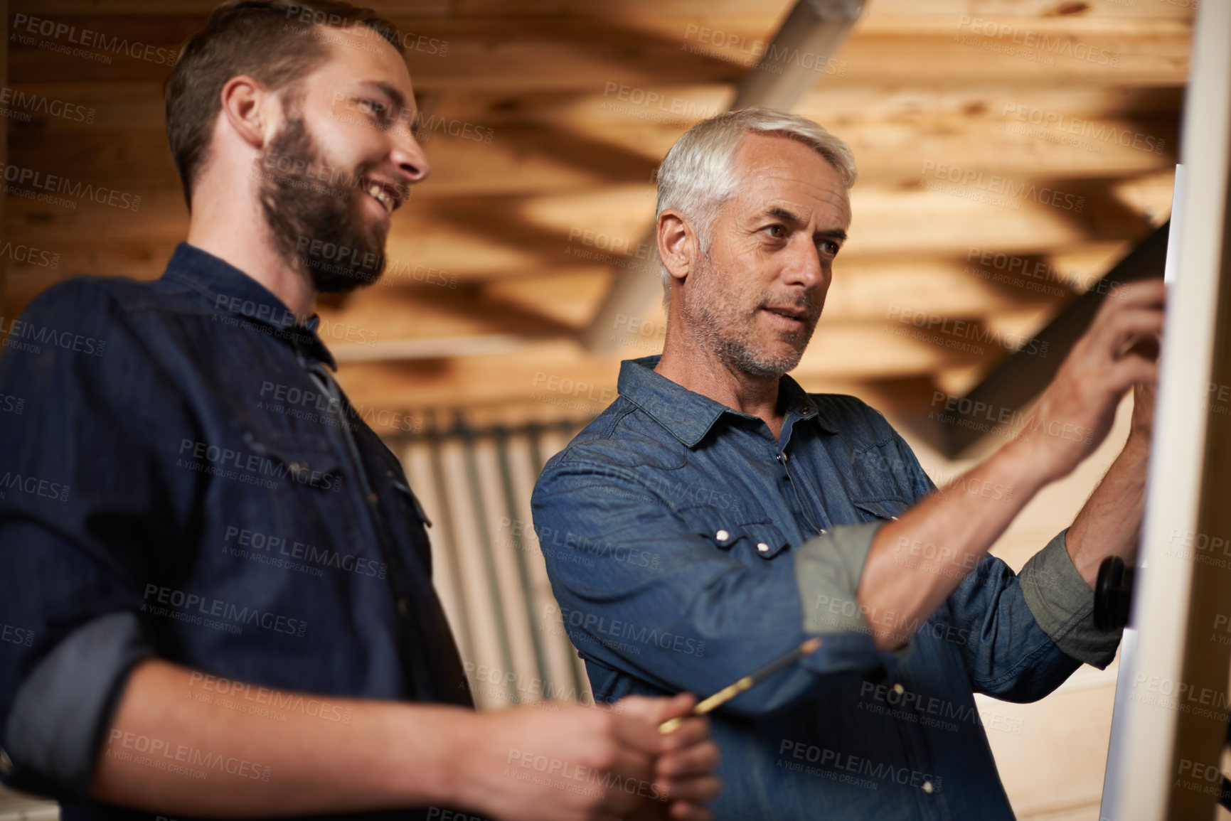 Buy stock photo Planning, brainstorming and architects by board in workshop for industrial carpentry project. Discussion, engineering and male industry apprentice working on ideas with mentor in office on site.