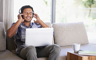 Buy stock photo Man, headphones and laptop for music or website, home and internet for streaming sound. Happy male person, relax and song app on couch for audio or podcast, student and online for education to learn