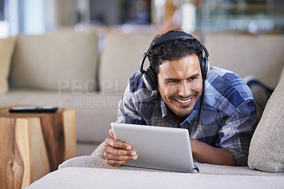 Buy stock photo Man, headphones and tablet for music in home, website and internet for streaming. Happy male person, relax and song app on couch for audio or podcast, lounge and online for blog or subscription