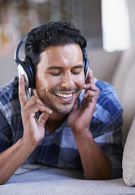 Buy stock photo Man, headphones and listening to podcast on couch, relax and streaming radio for music or sound. Happy male person, home and lying on sofa for peace, comfortable and hearing jazz playlist on weekend
