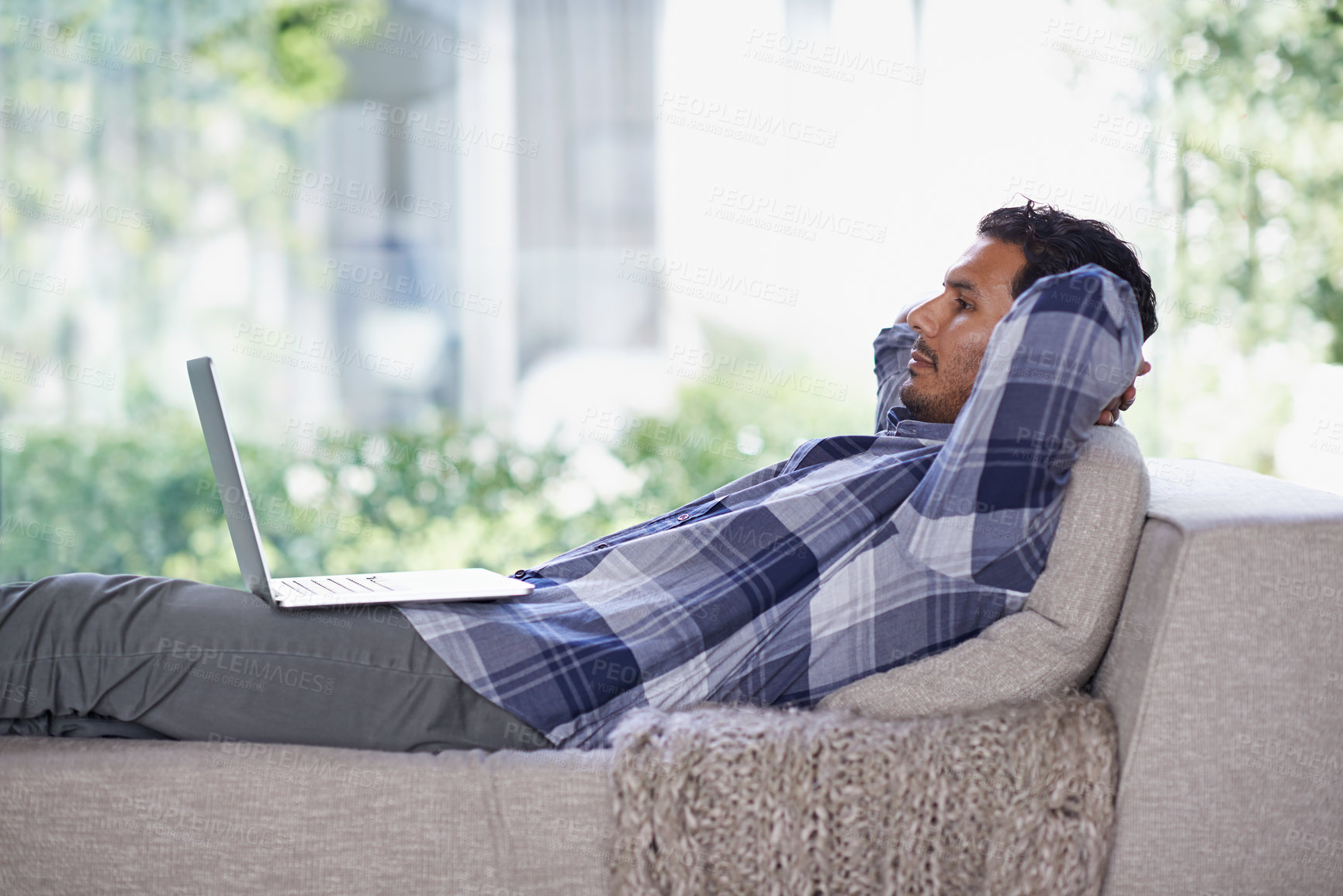 Buy stock photo Man, laptop and living room with home, rest and internet for relax and streaming. Indian person, web and tech with house, lounge or apartment for watching video and connectivity with subscription