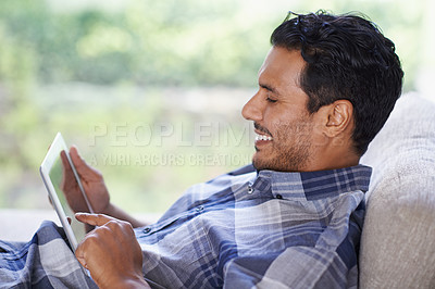 Buy stock photo Man, tablet and living room with home, smile and internet for relax and streaming. Indian person, web and tech with house, lounge or apartment for watching video and connectivity with subscription