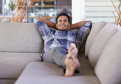 Buy stock photo Shot of a young ethnic man relaxing indoors on his couch