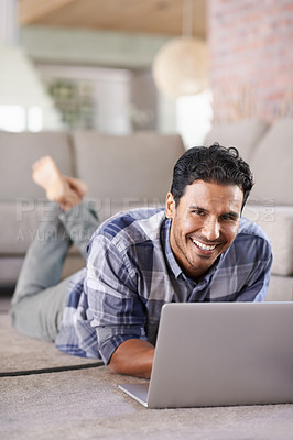 Buy stock photo A young man using his laptop at home