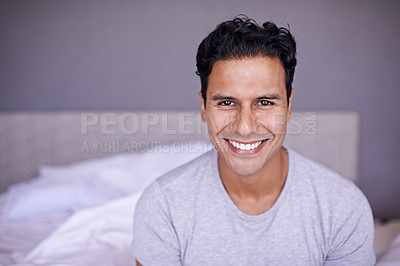 Buy stock photo Man, happy and relax in bedroom in portrait, wellness and confident on morning vacation on home. Young person, smile face and healthy on break on lazy weekend, pyjamas and calm on bed in apartment