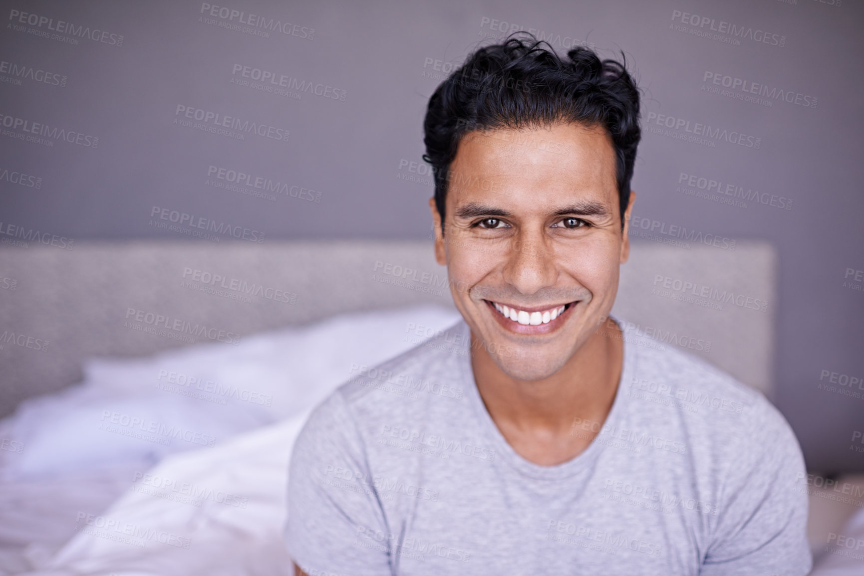 Buy stock photo Man, happy and relax in bedroom in portrait, wellness and confident on morning vacation on home. Young person, smile face and healthy on break on lazy weekend, pyjamas and calm on bed in apartment