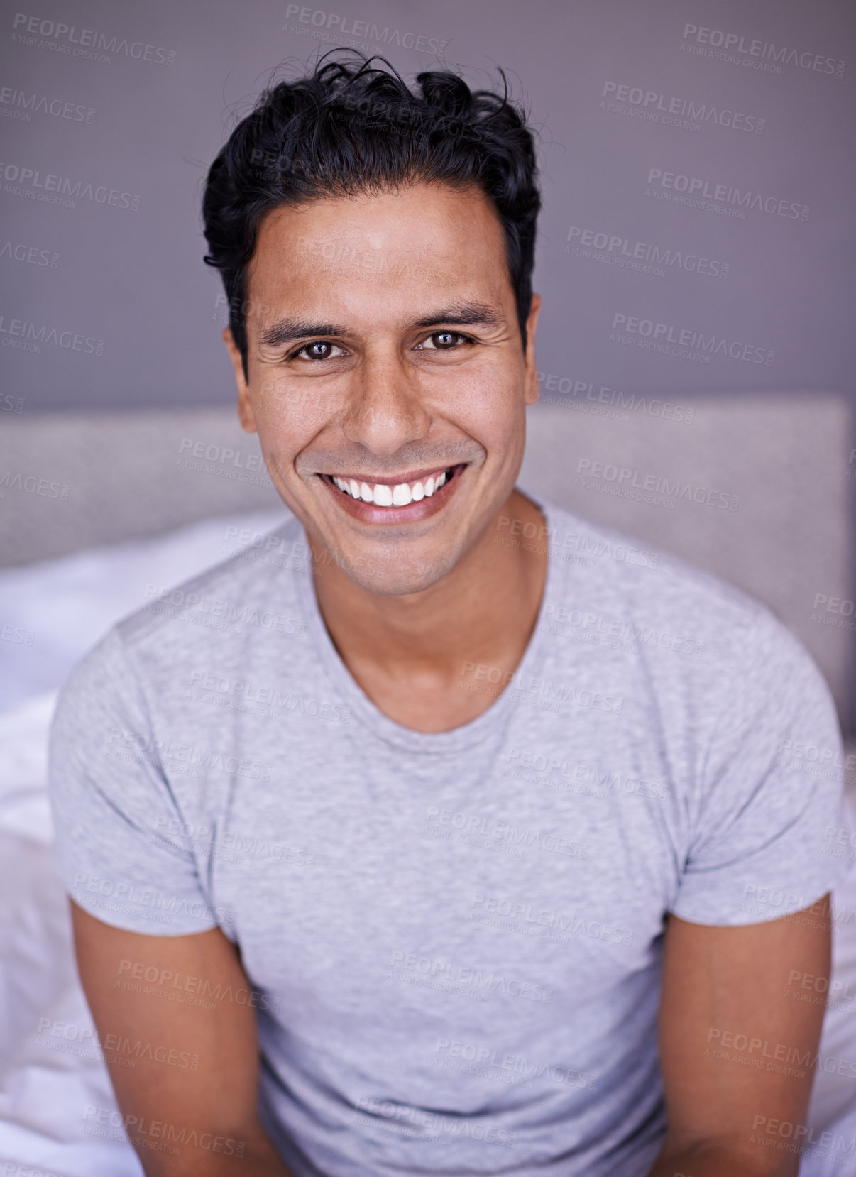 Buy stock photo Man, happy and wellness in bedroom in portrait, peace and confident on morning vacation on home. Young person, smile face and healthy on break on lazy weekend, pyjamas and rest on bed in apartment