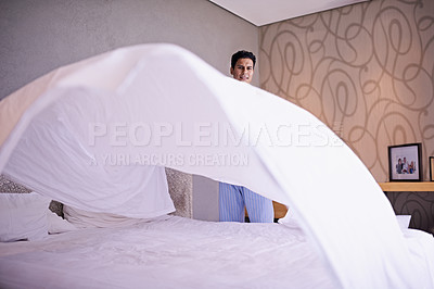 Buy stock photo Man, morning and making bed in home for hygiene and routine of change fresh linen on weekend. Tidy, bedroom or modern guy with happy for housekeeping, healthy or spring cleaning on vacation in house