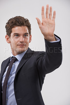 Buy stock photo Businessman, palm and hand with touch for interaction, virtual display or connection on a gray studio background. Isolated young man, user or business employee showing gesture sign, symbol or wait