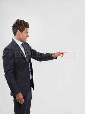 Buy stock photo Pointing, mockup and businessman in studio for direction hand gesture with marketing space. Career, mock up and confident professional male employee in suit with presentation by gray background.