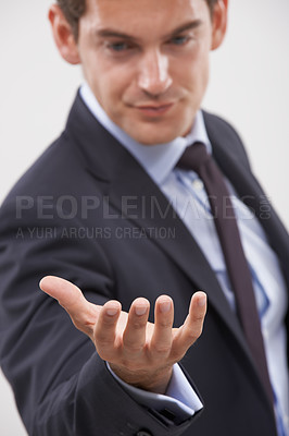 Buy stock photo Businessman, palm and hand with interaction for hologram or virtual display on a gray studio background. Isolated young man, user or business employee showing gesture sign, symbol or 3D technology