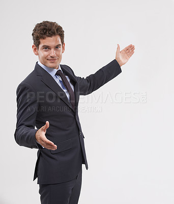 Buy stock photo A handsome young businessman presenting copyspace
