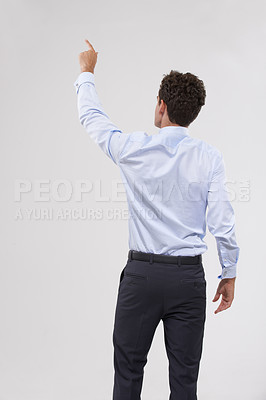Buy stock photo Pointing, mockup and back of businessman in studio for direction hand gesture with marketing space. Career, mock up and behind of professional male employee with presentation by gray background.