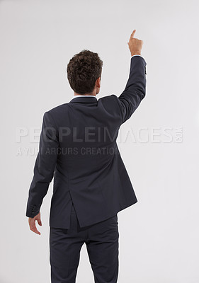 Buy stock photo Pointing, mockup and behind of businessman in studio for direction hand gesture with marketing space. Career, mock up and back of professional male employee with presentation by gray background.