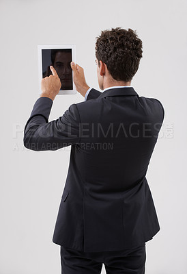 Buy stock photo Rearview shot of a businessman using a digital tablet