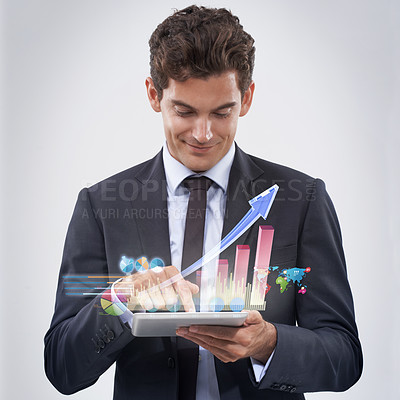 Buy stock photo Studio shot of a young businessman analyzing data using his digital tablet