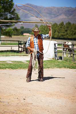 Buy stock photo Cowboy, ranch and lasso in boots, sun and straps for wrangler and Texas farmer at stable. Mature man, wild west and summer in agriculture, hat and male person with rope in farm job and environment