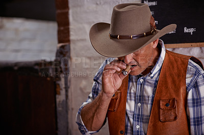 Buy stock photo Smoking, cigar and senior cowboy on ranch for farming, agriculture and stable for rodeo animals. Western, countryside and mature farmer, man and rancher with cigarette, tobacco and smoke in Texas