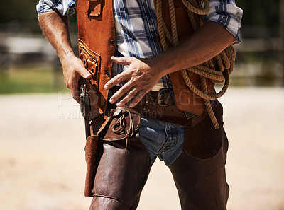 Buy stock photo Cropped shot of an unrecognizable cowboy drawing his gun