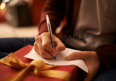 Buy stock photo Hands, writing letter and Christmas in home with box, present and message with festive wish in closeup. Person, pen and paper with notes, gift and package with kindness, celebration and xmas card