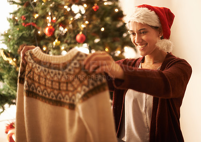 Buy stock photo Woman, smile and sweater in hand on Christmas for gift,  holding and happiness for festive season. Tree, lights and person with present in home for gratitude, surprise and December in living room