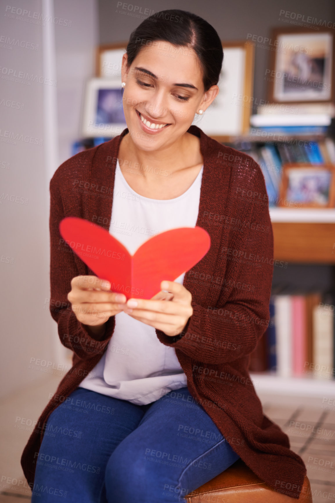 Buy stock photo Shot of an attractive young woman reading a valentine&#039;s day card at home