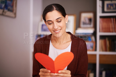 Buy stock photo Woman, reading and heart letter in home for valentines day, memory and happy for celebration with sign. Girl, person and greeting card for love, kindness and note for relationship with smile in house