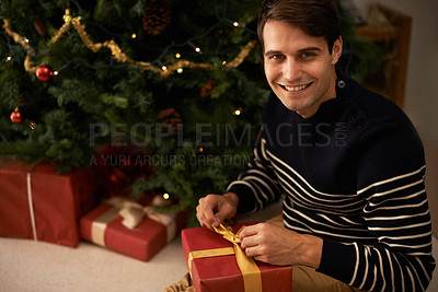 Buy stock photo Portrait, Christmas tree and man wrapping box in home for preparation of holiday event of tradition. Gift, present and smile with happy young person in apartment for December celebration or vacation