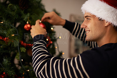 Buy stock photo Living room, house and man with smile for decorations on tree for Christmas party or celebration. Apartment, happiness and male person with joy in family home for tradition and vacation for holiday