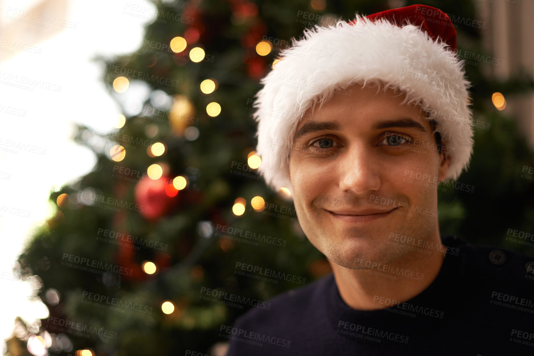 Buy stock photo Shot of a handsome young man getting ready for Christmas