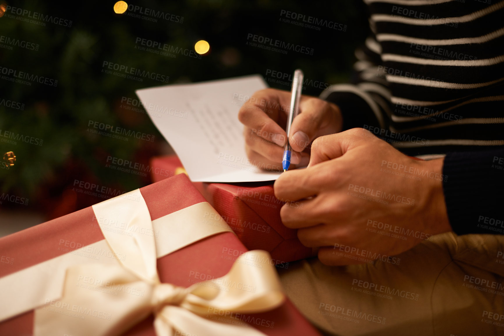Buy stock photo Writing, hands and man with card and gift for Christmas event or party at home for family. Celebration, paper and closeup of male person with pen for letter with present boxes for festive holiday.