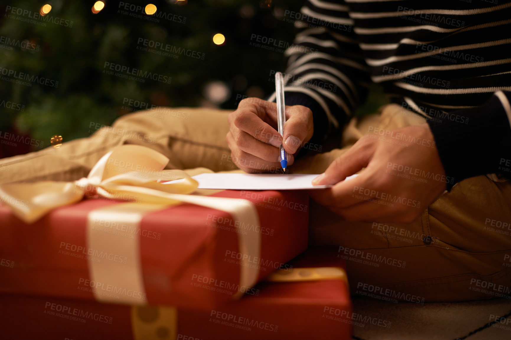 Buy stock photo Pen, hands and man with card and present for Christmas event or party at home for family. Celebration, paper and closeup of male person writing letter with gift boxes for xmas festive holiday.