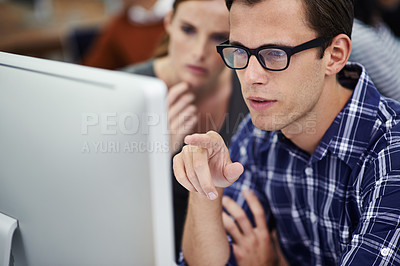 Buy stock photo Shot of coworkers sitting at a computer in an office