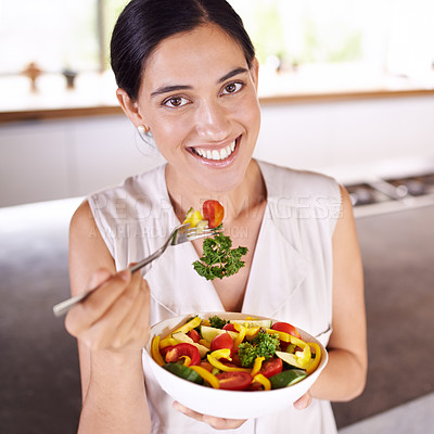 Buy stock photo Young woman enjoying a salad while standing in her kitchen