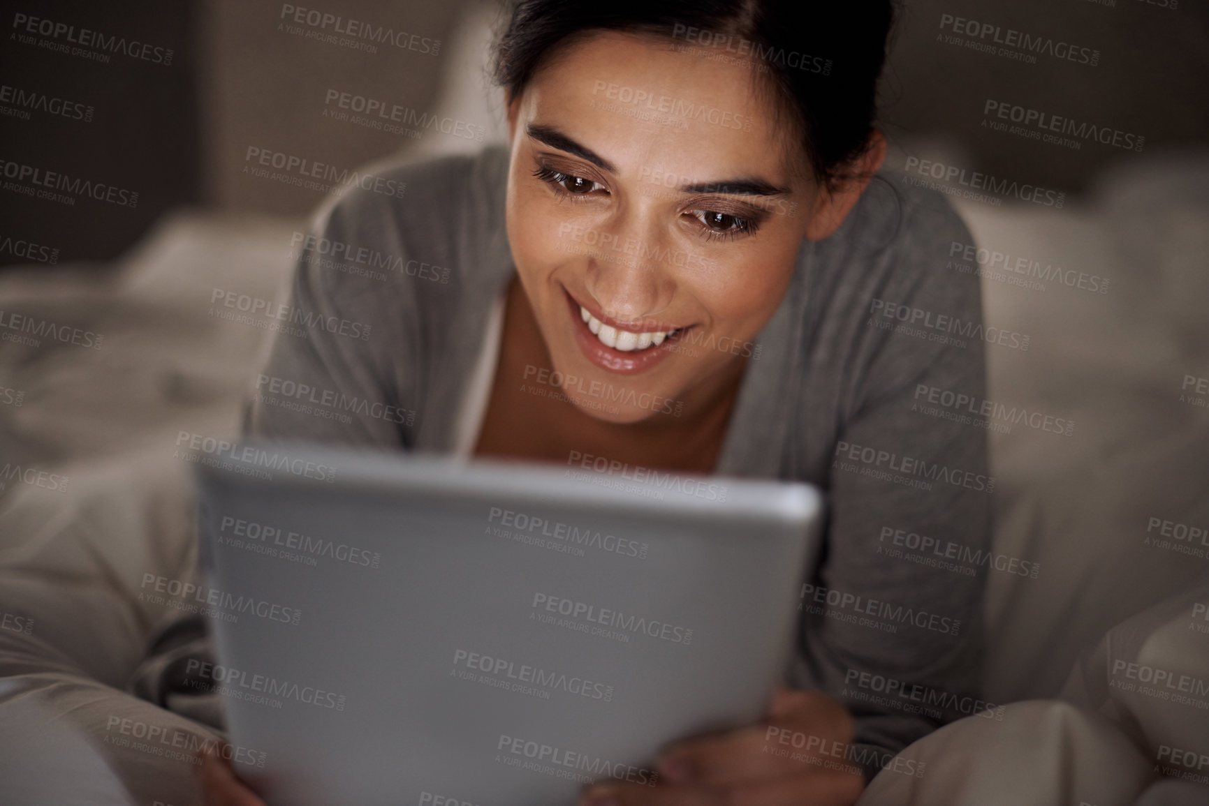Buy stock photo Cropped shot of an attractive young woman using her tablet in bed