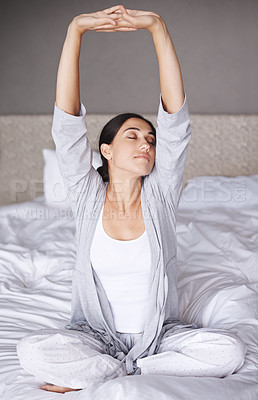 Buy stock photo An attractive young woman stretching in bed after waking up