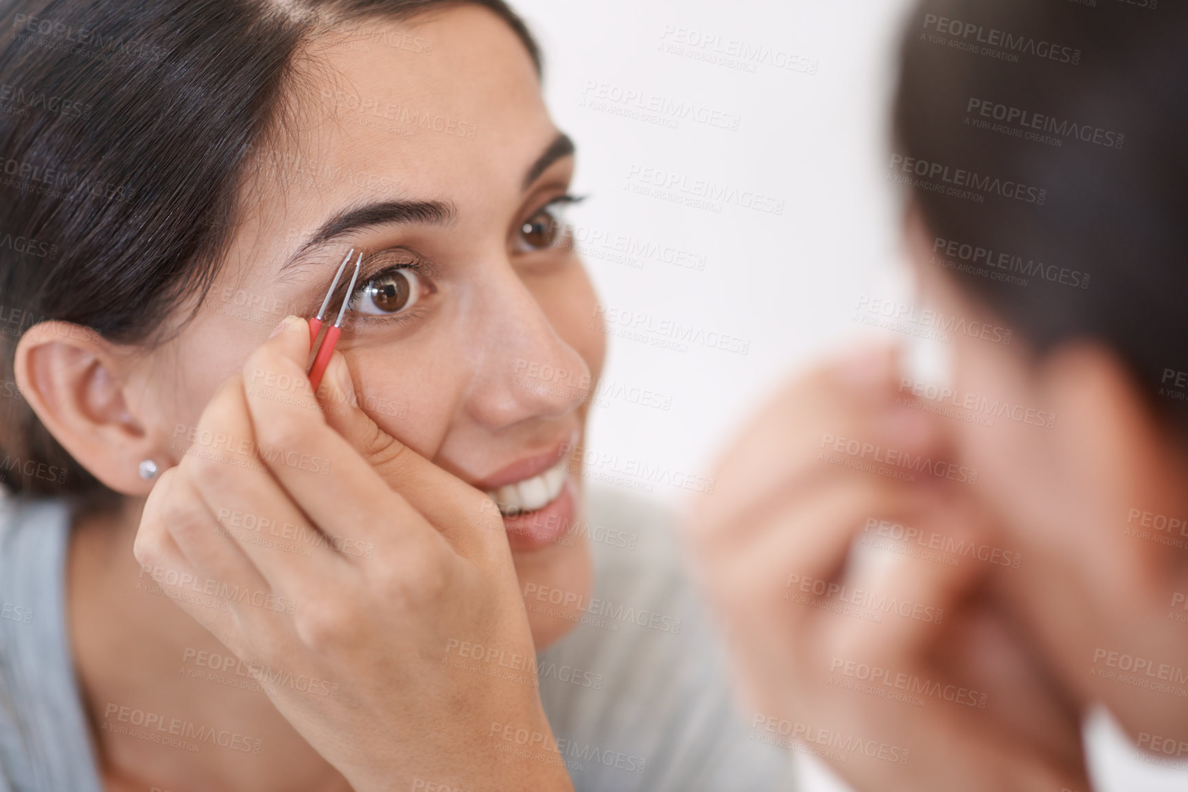 Buy stock photo A young woman tweezing her eyebrows
